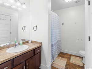 Full bathroom featuring vanity, toilet, baseboards, and a shower with curtain