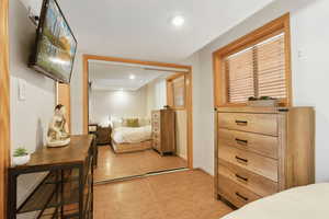 Bedroom with a closet, light wood finished floors, recessed lighting, and baseboards