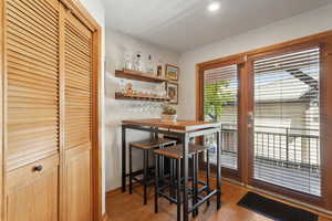 Dining area with light wood-style floors, a dry bar, and baseboards
