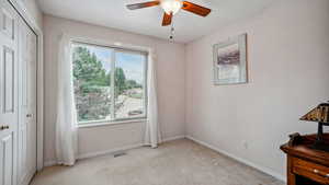 Unfurnished bedroom featuring multiple windows, light carpet, a closet, and baseboards