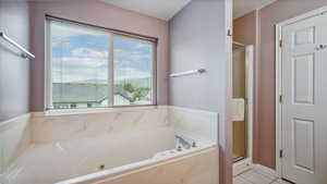 Full bath with plenty of natural light, a jetted tub, a stall shower, and tile patterned floors