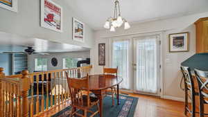 Dining space featuring a chandelier, wood finished floors, french doors, baseboards, and ceiling fan