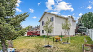 View of property exterior featuring a lawn and a wooden deck