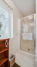 Bathroom with a shower stall and baseboards