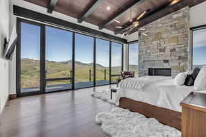 Bedroom featuring a mountain view, a fireplace, wooden ceiling, wood finished floors, and access to outside