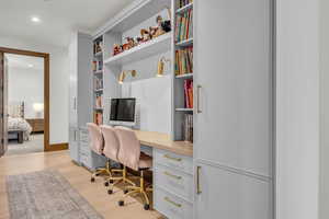 Office space featuring light wood-style flooring and recessed lighting