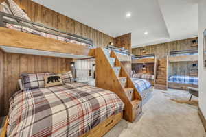 Bedroom featuring wood walls, carpet flooring, and recessed lighting