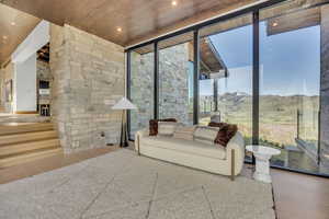 Living area with wood finished floors, floor to ceiling windows, a mountain view, wooden ceiling, and recessed lighting