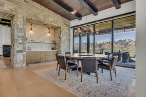 Dining space with a mountain view, light wood-type flooring, a chandelier, and wooden ceiling