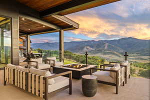 Patio terrace at dusk featuring an outdoor living space with a fire pit, a mountain view, and a patio