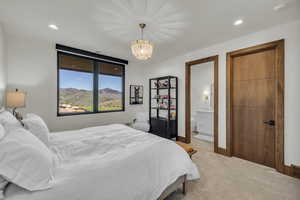 Bedroom with light carpet, recessed lighting, a mountain view, a chandelier, and ensuite bath