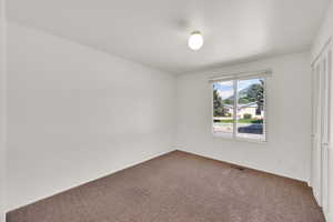Unfurnished bedroom featuring carpet, baseboards, and a closet