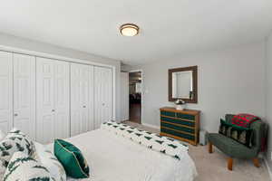 Carpeted bedroom featuring a closet and baseboards