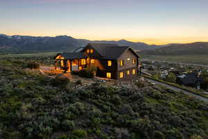 View of front of home with a mountain view and a balcony