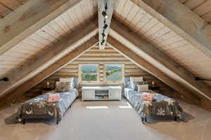 Bedroom with wood ceiling, log walls, and carpet flooring