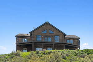 Rear view of house featuring log siding and a deck