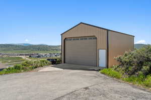 Detached garage featuring a mountain view and driveway