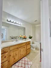 Bathroom featuring vanity, toilet, tile patterned floors, shower / bathtub combination, and a textured ceiling