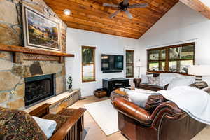 Beautiful great room with vaulted wood ceiling and glowing fireplace