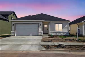 Ranch-style house with concrete driveway, a garage, roof with shingles, and stone siding