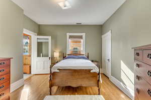 Bedroom featuring light wood-style floors, a skylight, and baseboards