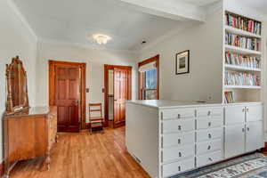 Foyer with ornamental molding and light wood-style flooring