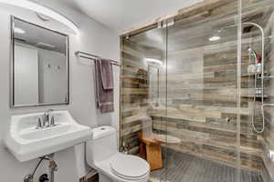 Full bath with toilet, a stall shower, and tile patterned floors
