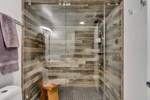 Full bathroom with toilet, a shower stall, and a sauna