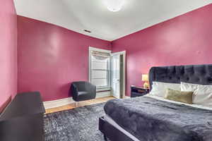 Bedroom with wood finished floors and baseboards