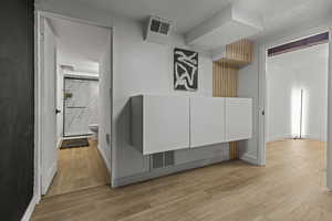 Hallway with light wood-type flooring and baseboards