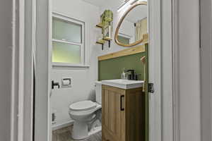 Bathroom featuring toilet, wood finished floors, and vanity