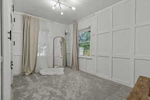 Upstairs bedroom featuring new carpet flooring, modern wood paneling, and lots of built in storage/closet space.