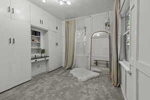 Upstairs bedroom featuring new carpet flooring, modern wood paneling, and lots of built in storage/closet space.
