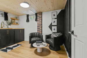 Sitting room with wooden ceiling and light wood-type flooring