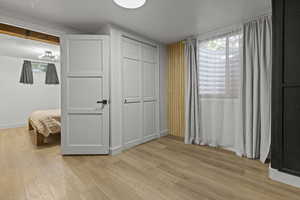 Unfurnished bedroom with light wood finished floors, baseboards, a closet, and a chandelier