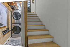 Laundry room with stacked washer / dryer. Oak tread stairs.
