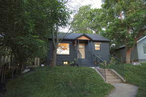 Bungalow-style home with a front yard and roof with shingles