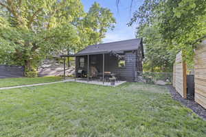 Back of house with a patio area and roof with shingles