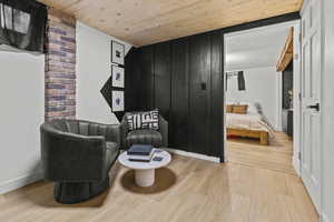 Living area featuring wooden ceiling, wood finished floors, and baseboards