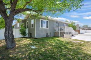 Rear view of property featuring a patio, a wooden deck, and stucco siding