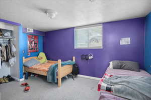 Bedroom with baseboards, a closet, and a textured ceiling