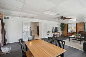 Dining area with french doors, wood finished floors, a drop ceiling, ceiling fan, and baseboards