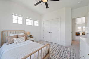 Bedroom featuring light carpet, multiple windows, and a closet