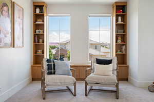Sitting room featuring light colored carpet and baseboards