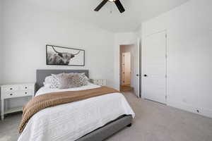 Bedroom with light carpet and a ceiling fan