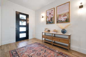 Foyer entrance with wood-type flooring and baseboards