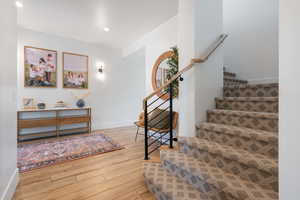 Stairway with wood-type flooring, recessed lighting, and baseboards