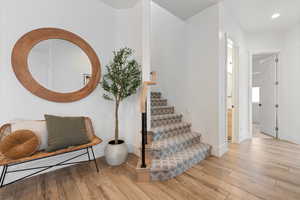 Staircase featuring hardwood / wood-style flooring, baseboards, and recessed lighting
