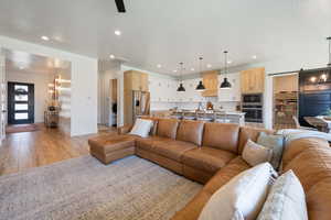 Living area featuring baseboards, a chandelier, recessed lighting, and light wood finished floors