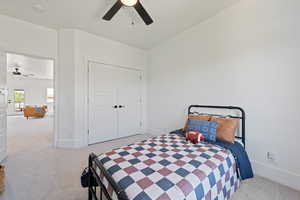 Bedroom with carpet flooring, baseboards, a closet, and a ceiling fan